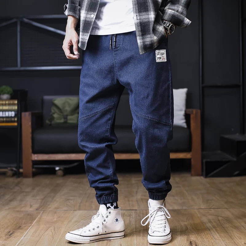 Plus size men's loose jogger jeans by Ansoff featuring streetwear harem style, cargo pockets, and ankle-length denim trousers.