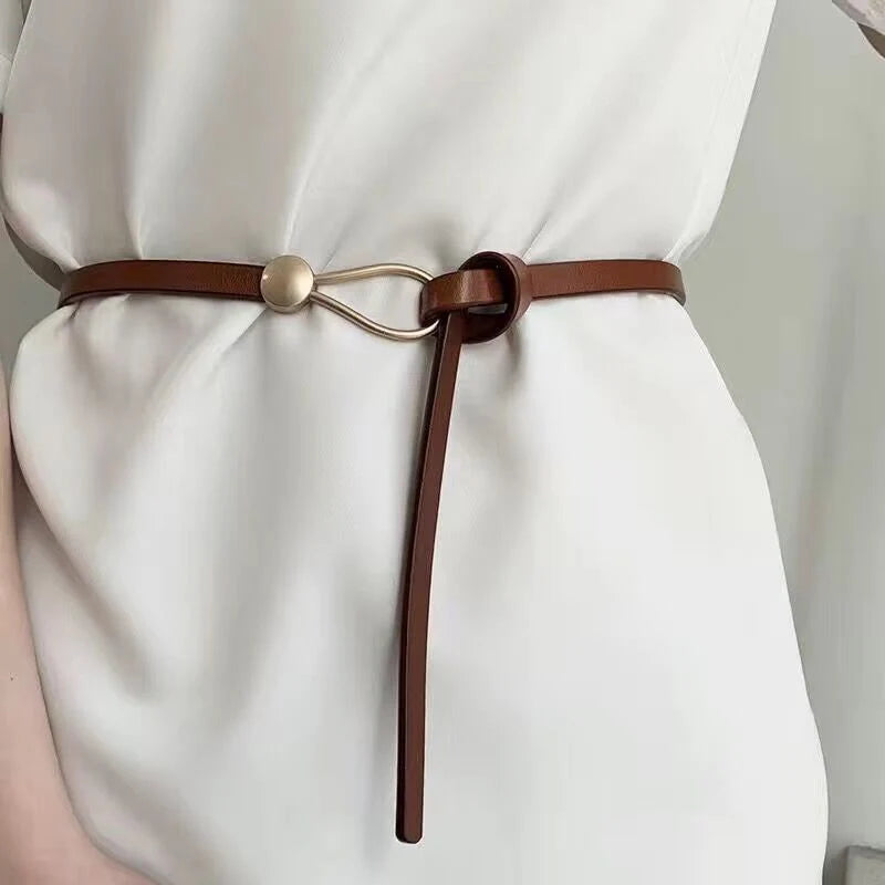 White and black thin leather belt for women with a bow detail, loop strap design, ideal as a dress or coat waistband accessory.