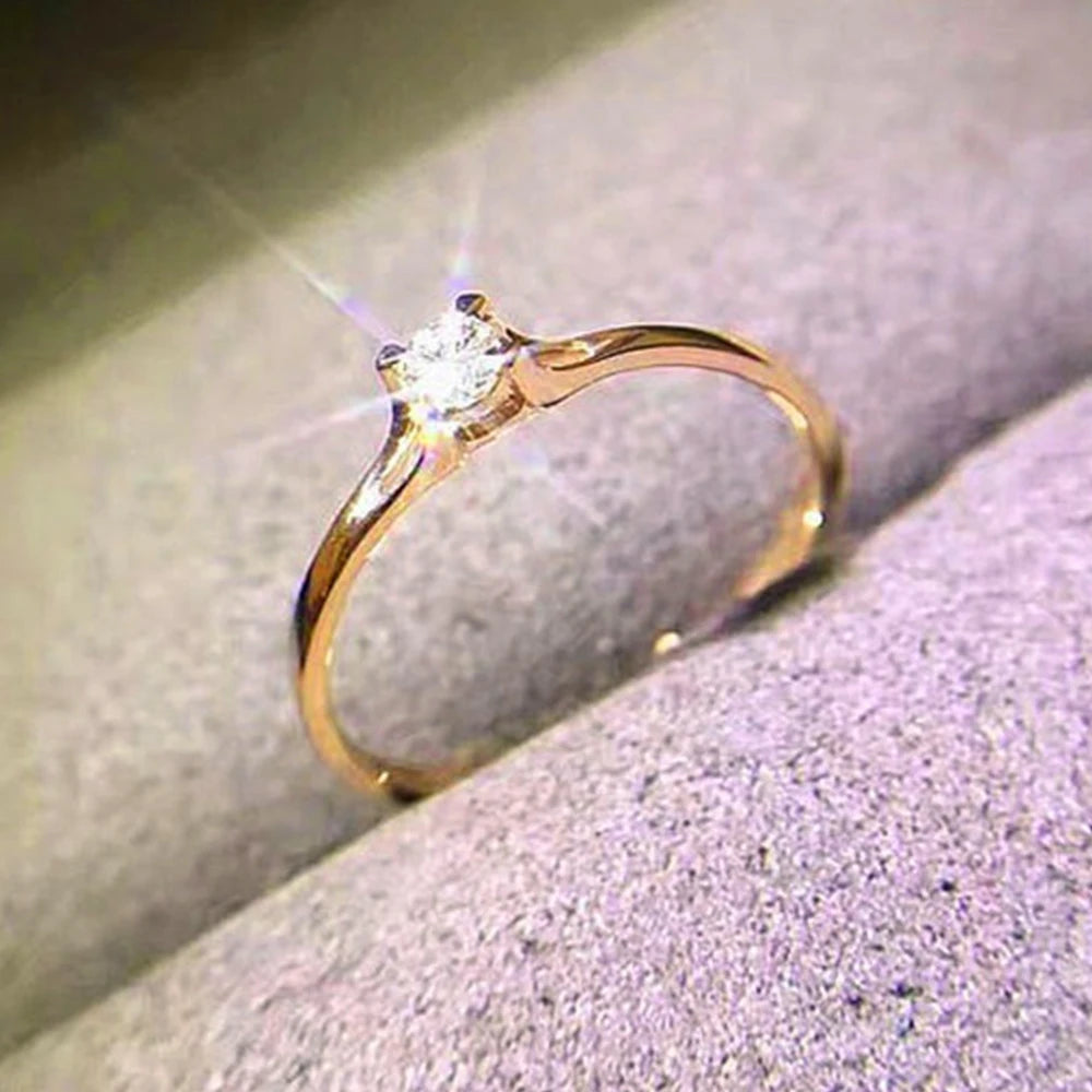 Ansoff Huitan minimalist women's wedding ring with 4mm cubic zirconia, simple and elegant finger jewelry for engagement or special occasions.