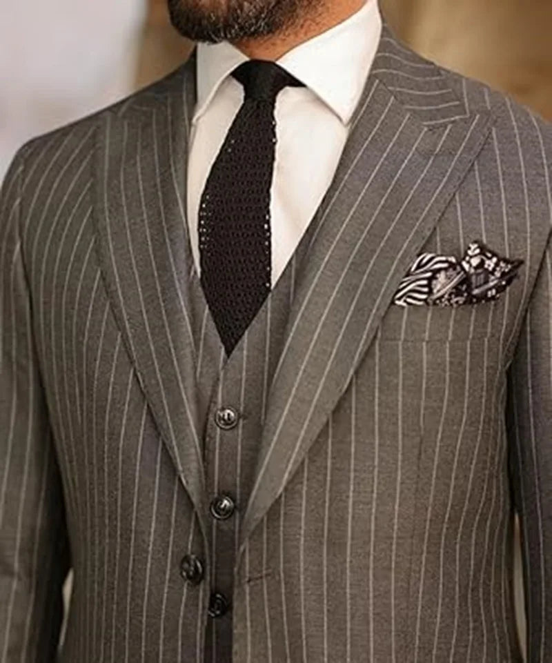 Men's elegant pinstripe three-piece suit by Ansoff, featuring blazer, vest, and pants with peak lapels for wedding or business.