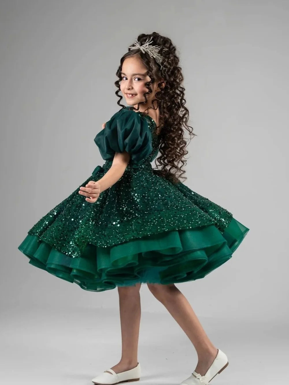 Girls emerald green sequin princess dress with puff sleeves, layered tulle skirt, bow decor, ideal for formal parties and dancing.