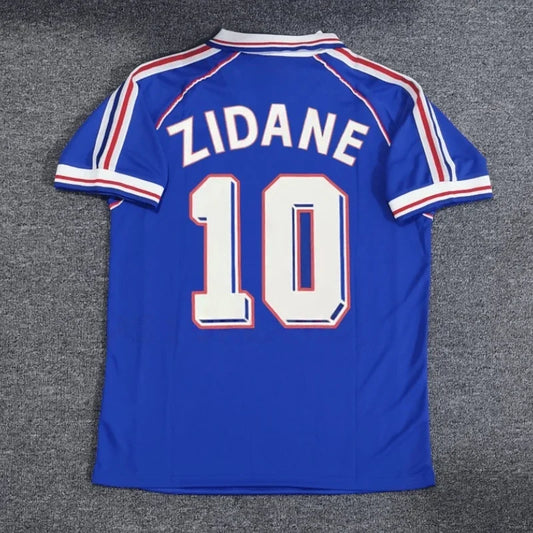 Retro Argentina and France national team jerseys featuring Messi, Zidane, Henry, and Batistuta by Ansoff, displayed on a flat surface.