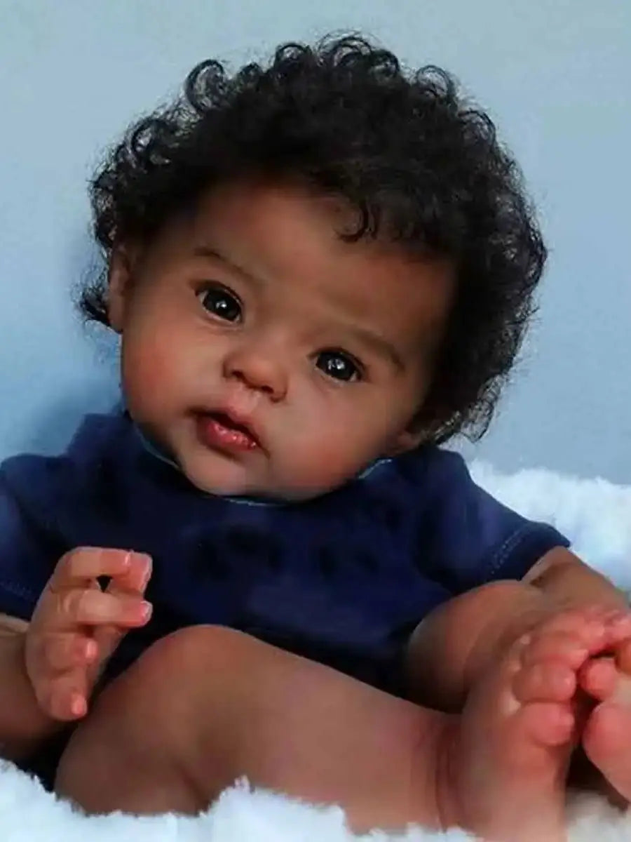 Black Reborn baby doll with soft cloth body, curly hair, and realistic features by Ansoff, designed to resemble a real newborn baby.